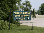 Green roadside sign that reads "Fenton Lakes Sportsmans Club"