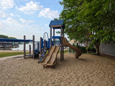 play structure in sand with lake in background